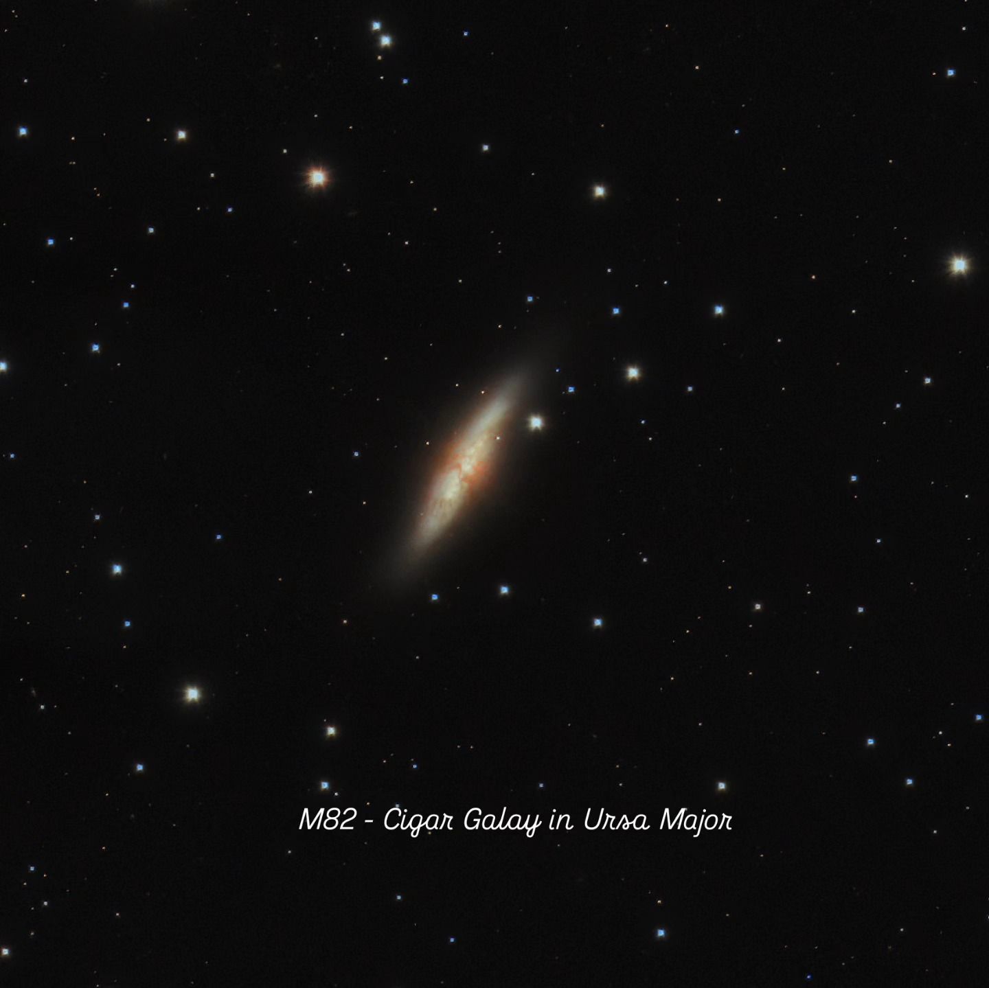 Edge-on, cigar-shaped galaxy with reddish filaments at its core, against a dark star field