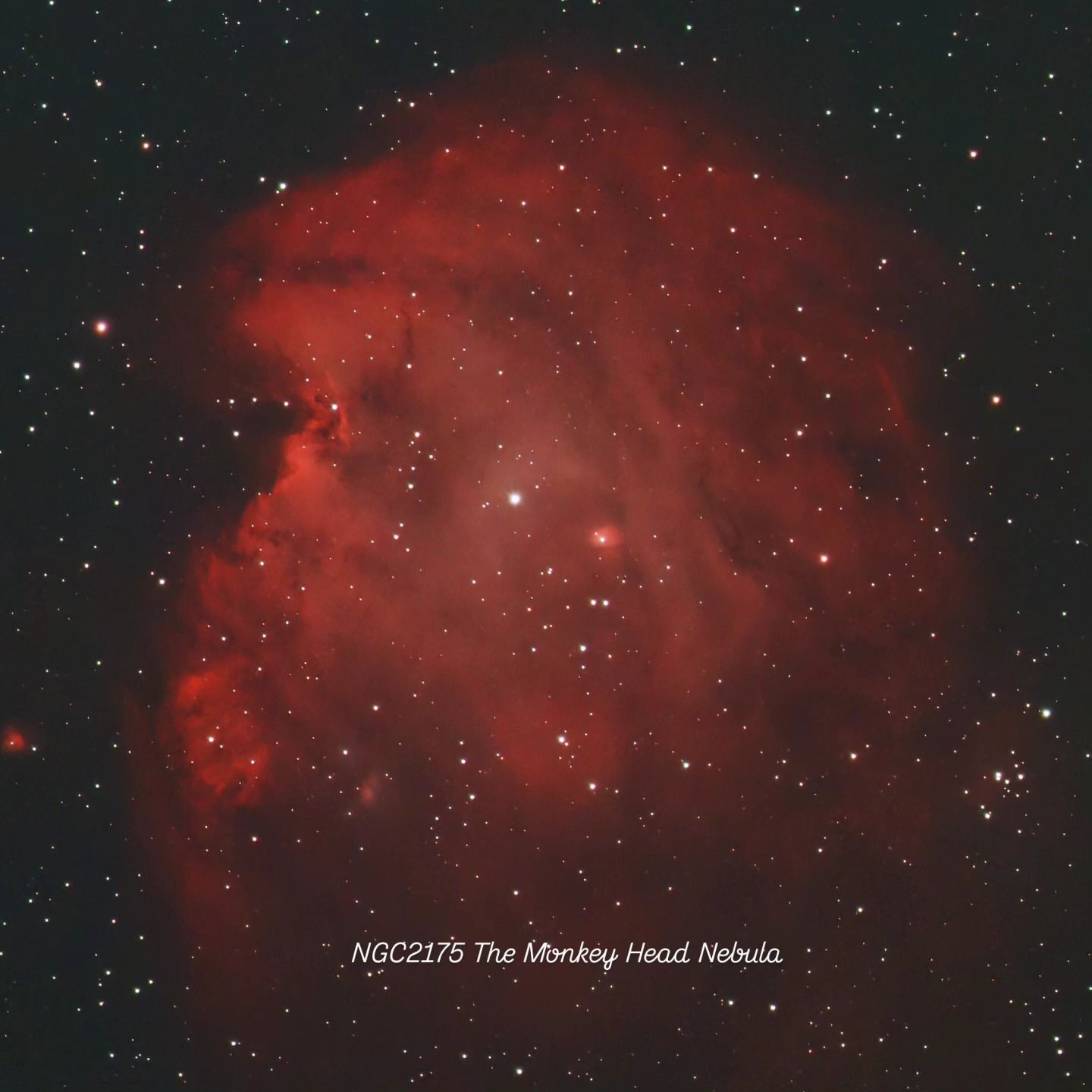 Large, billowing red emission nebula with dark lanes, filling the frame