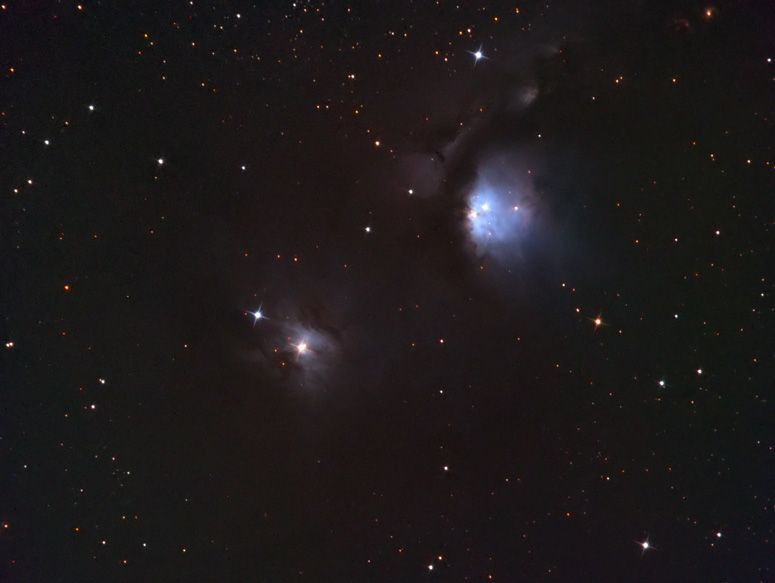 Small blue glowing reflection nebula at upper right with a second fainter knot of nebulosity at lower left
