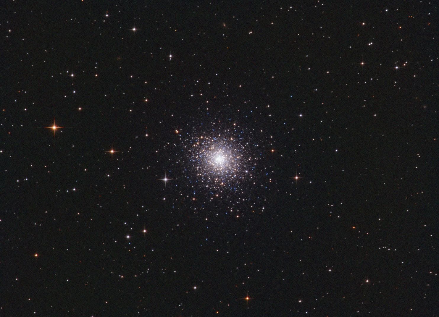 Compact globular cluster of white stars at right of centre in a star field