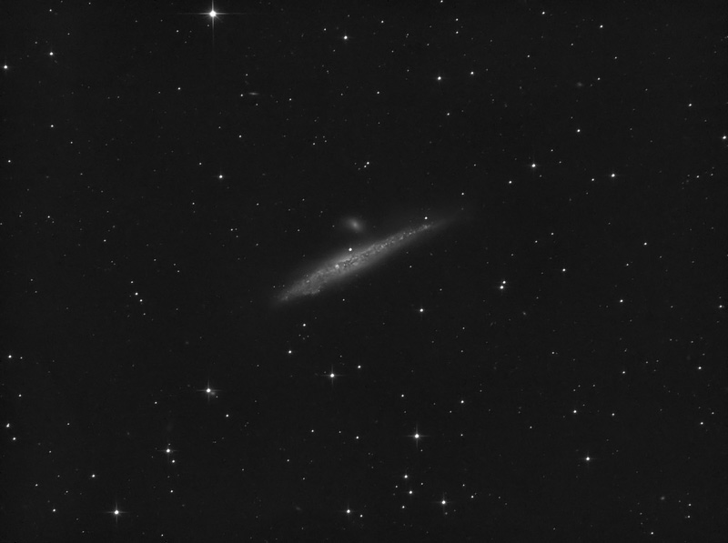 Thin, slightly warped edge-on galaxy with a small companion just above it