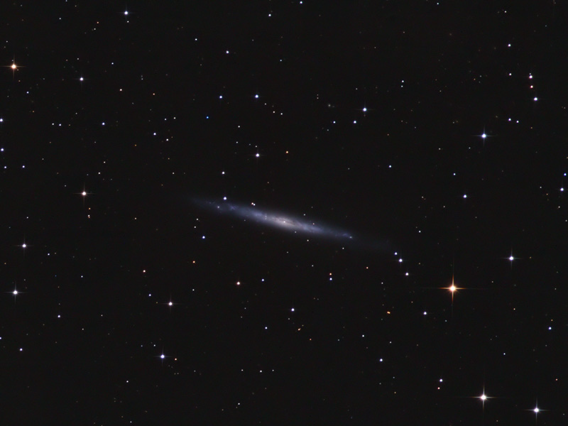 Faint, thin edge-on galaxy crossing the centre of a star field