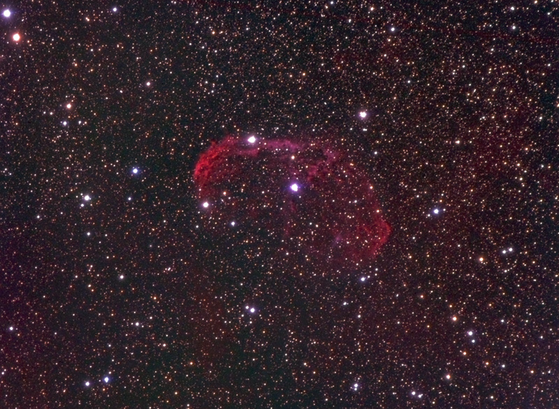Red crescent-shaped shell of gas in a dense Milky Way star field