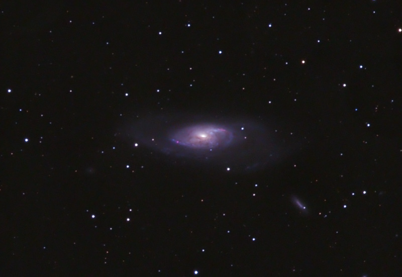 Elongated spiral galaxy with a bright core and a small companion galaxy below right