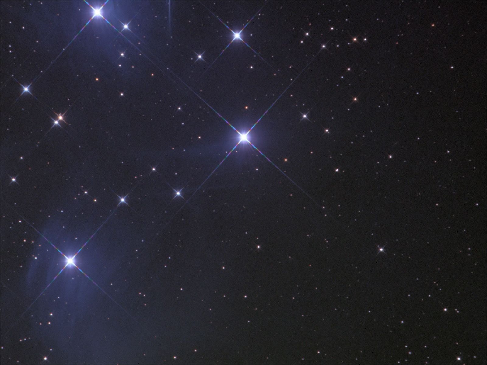 Bright blue-white stars with diffraction spikes surrounded by faint blue haze